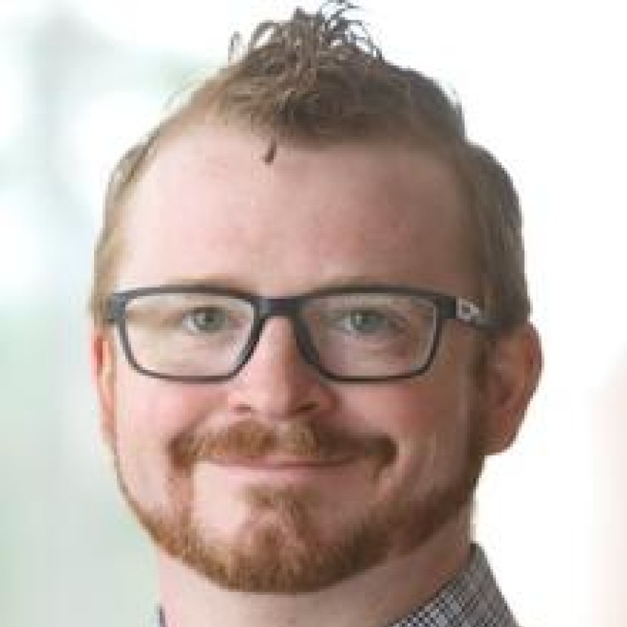 Headshot of man smiling.