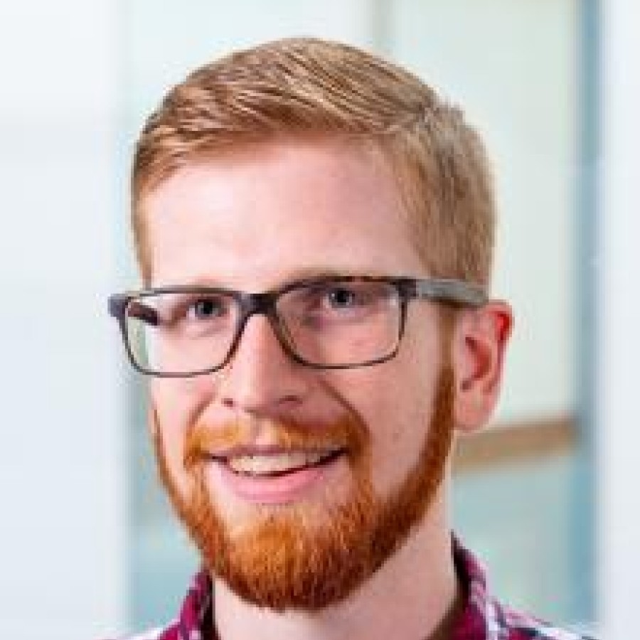 Headshot of man smiling.