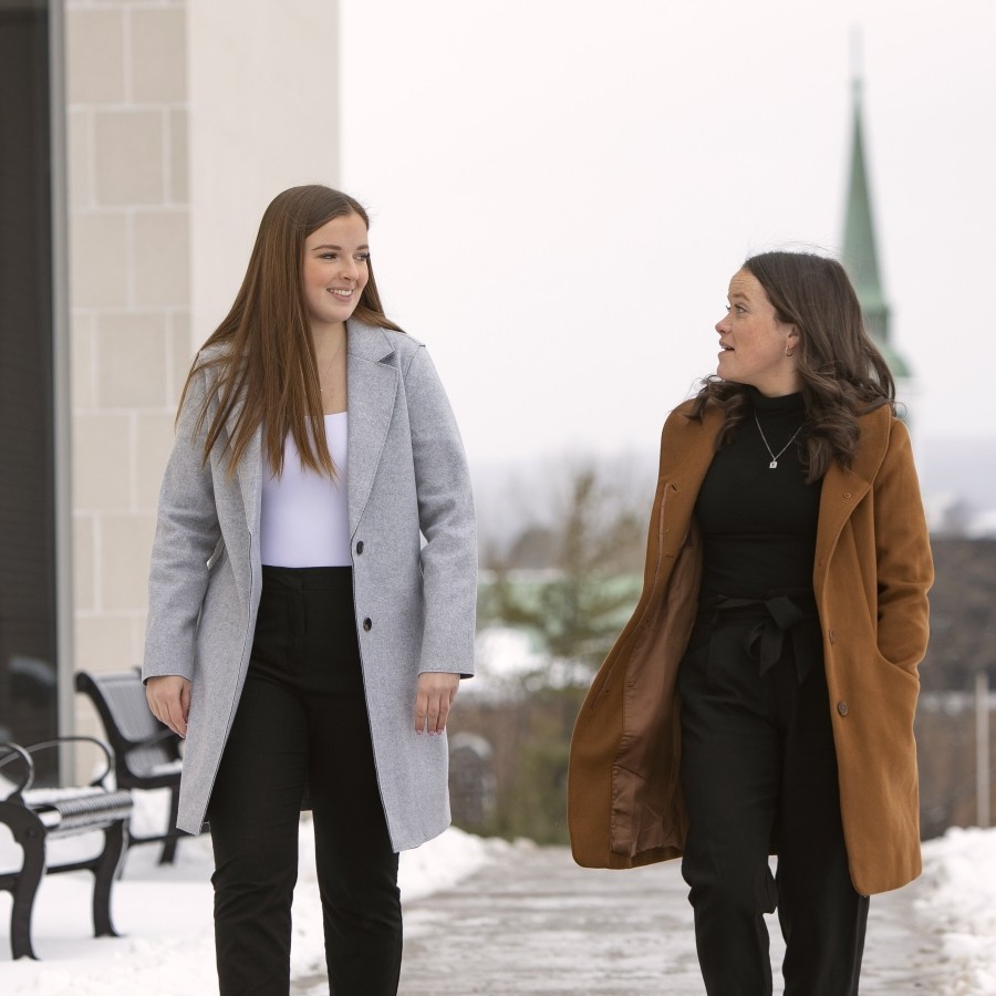 Close up of students walking on the side walk located near Mulroney Hall on a winter day.