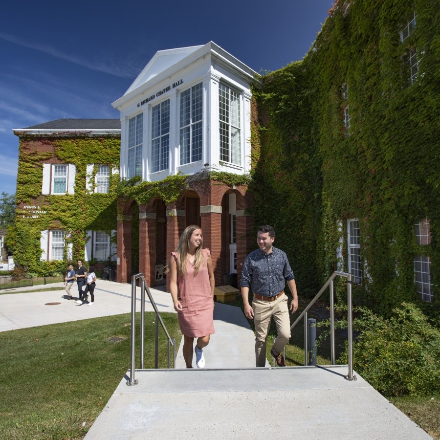 Students walking up the stairs outside the Angus L. MacDonald library on a sunny day.