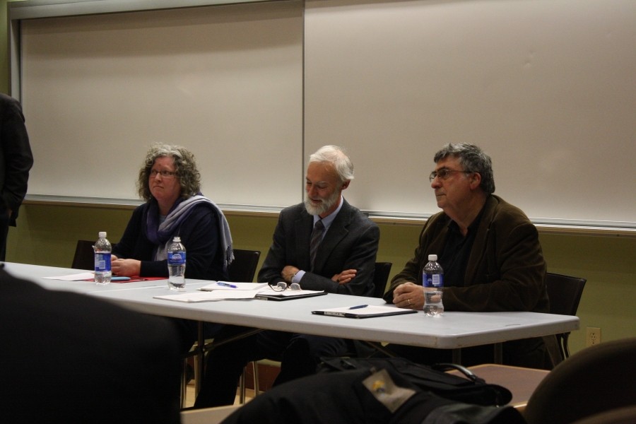 In the picture, 3 Professors sit in a table while on a Q&amp;A session