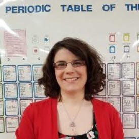A woman standing in front of a poster